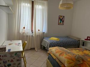 een kamer met 2 bedden, een tafel en een raam bij il passero in Costa