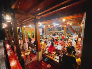een groep mensen die in een restaurant zitten bij A Khoan Homestay - Venuestay in Mai Chau