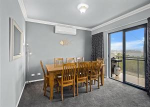 a dining room with a wooden table and chairs at Waters Edge in Nambucca Heads