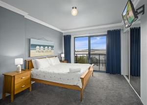 a bedroom with a bed and a large window at Waters Edge in Nambucca Heads