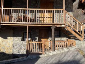 a building with a wooden balcony and a staircase at Maison Vallouise, 2 pièces, 4 personnes - FR-1-330G-140 in Puy-Saint-Vincent