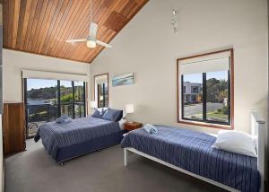 a bedroom with two beds and a ceiling fan at Peninsula in Sawtell