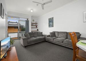 un soggiorno con due divani e una TV a schermo piatto di Coasters 9 a Sawtell