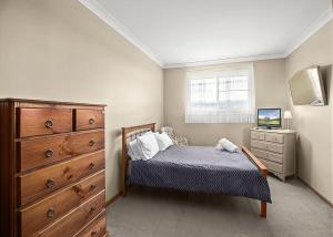 1 dormitorio con 1 cama, vestidor y TV en Robys Retreat, en Sawtell