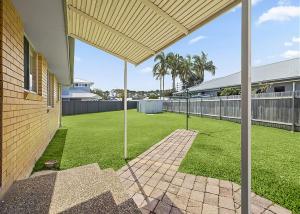 a backyard with a grassy yard with a house at Robys Retreat in Sawtell