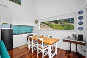 cocina con mesa de madera y ventana en Ciao Korora, en Coffs Harbour