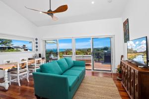 sala de estar con sofá azul y mesa en Ciao Korora, en Coffs Harbour