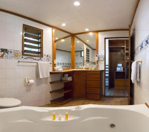 First Landing Beach Resort & Villas في لوتوكا: حمام مع حوض ومرآة كبيرة