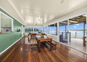a dining room with a table and views of the ocean at Lobster Cottage in Sawtell