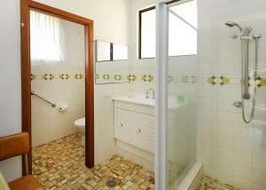 a bathroom with a shower and a sink and a toilet at Rose Cottage in Sawtell