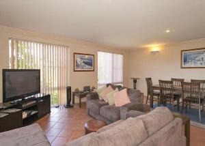 a living room with a couch and a flat screen tv at 1/17 22nd Ave - Sawtell, NSW in Sawtell