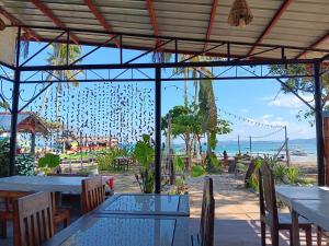 a restaurant with tables and chairs and a view of the ocean at Casa Leonora in Sabang