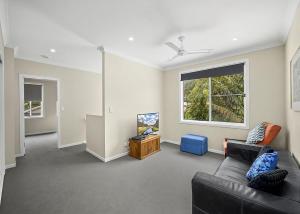 a living room with a couch and a window at Sawtell Swells in Sawtell