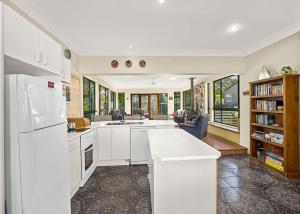 a kitchen with white appliances and a living room at Ronnie s Cottage in Mylestom