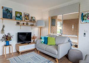 a living room with a couch and a tv at Lemongrass in Sawtell