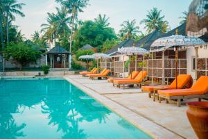ein Pool des Resorts mit orangefarbenen Stühlen und Sonnenschirmen in der Unterkunft Les Villas Ottalia Gili Meno in Gili Meno