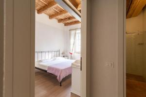 1 dormitorio con cama blanca y ventana en Residence Corte San Carlo, en Colà di Lazise