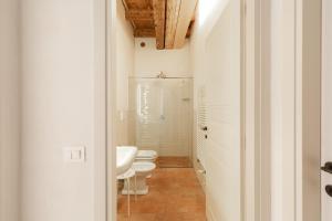 bagno bianco con 2 servizi igienici e lavandino di Residence Corte San Carlo a Colà