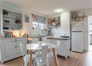 a kitchen with white appliances and a table and chairs at Lemongrass in Sawtell