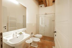 a white bathroom with a sink and a toilet at Residence Corte San Carlo in Colà di Lazise