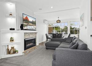 a living room with a couch and a fireplace at Sea Breeze in Coffs Harbour