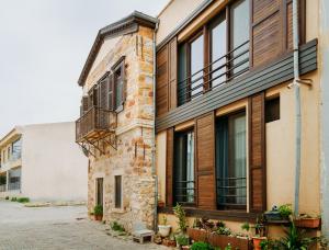 an old brick building with windows and a balcony at Nill's Stone House otel in Çeşme