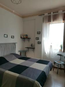 a bedroom with a black and white bed and a window at Trapani Emotions apartment in Valderice