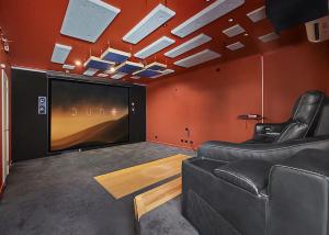 uma sala de estar com um sofá e uma televisão de ecrã grande em Gurruja Retreat em Scotts Head