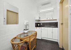 una cucina bianca con tavolo e lavandino di Coasters 30 a Sawtell