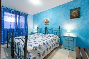 a blue bedroom with a bed and blue walls at Villetta Bacio del Sole in Sìnnai