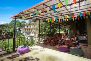 Un groupe de personnes assises à une table sous une pergola dans l'établissement Downtown Hostel Ella, à Ella