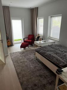 ein Schlafzimmer mit einem Bett, einem Stuhl und einem Schreibtisch in der Unterkunft Modern stor villa nära havet och 10 min till city in Göteborg