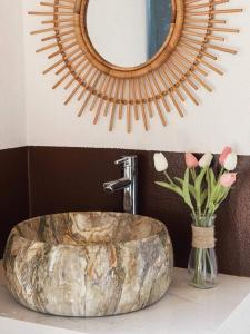 a bathroom with a stone sink and a mirror at A Khoan Homestay - Venuestay in Mai Chau