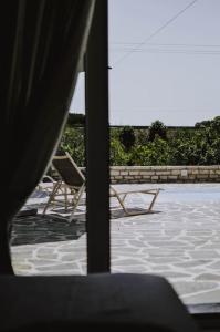 a view of a patio with two chairs and an umbrella at Blue in Green South in Kastrosikia +14 photos