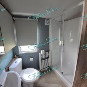 a bathroom with a white toilet and a shower at Q8 ocean edge caravan park in Heysham