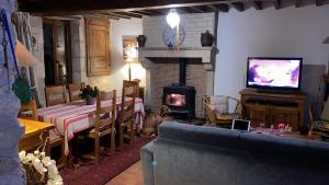 a living room with a fireplace and a couch and a television at La Petite Breuille in Lainsecq +23 photos