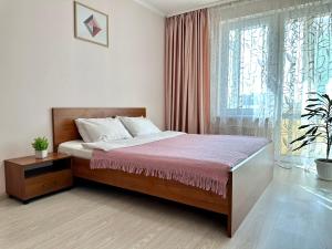 um quarto com uma cama e uma grande janela em Lux apartments in the city center, near the park and Zlata Plaza em Rivne