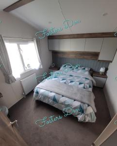 a bedroom with a bed with blue and white pillows at Q8 ocean edge caravan park in Heysham