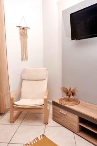 ein Wohnzimmer mit einem Stuhl und einem TV in der Unterkunft Boho House Florina in Florina