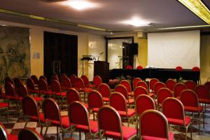 an empty room with red chairs and a stage at GRAND HOTEL LE FONTI in Chianciano Terme