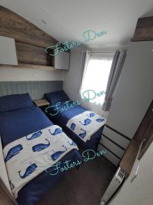 a small bedroom with two beds and a window at Q8 ocean edge caravan park in Heysham