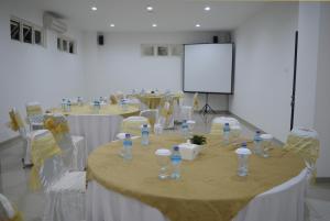 - une salle de conférence avec des tables, des bouteilles d'eau et des chaises dans l'établissement M Hotel, à Mataram
