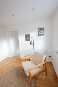 ein weißes Wohnzimmer mit einem Stuhl und einer Lampe in der Unterkunft Travetraum in Lübeck
