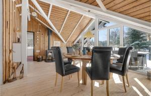 a dining room with a wooden table and black chairs at 3 Bedroom Stunning Home In Fjerritslev in Fjerritslev