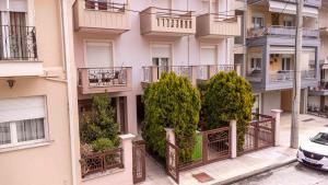 un bâtiment avec des balcons et des arbres sur son côté dans l'établissement Boho House Florina, à Flórina