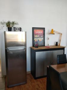 eine Küche mit einem Kühlschrank aus Edelstahl und einem Schreibtisch in der Unterkunft Appartement de charme bord de Loire in Saumur