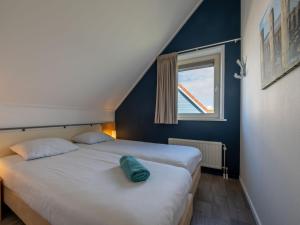2 Betten in einem kleinen Zimmer mit Fenster in der Unterkunft Antibes 234 - Kustpark Village Scaldia in Hoofdplaat