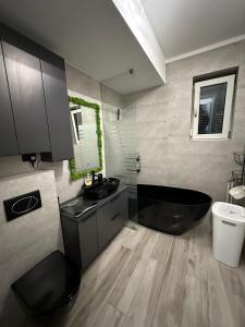 baño con bañera negra y lavamanos en Apartament Ella C&C Residence, en Mamaia Nord – Năvodari
