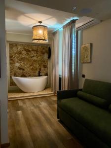 - un salon avec une baignoire et un canapé dans l'établissement Agriturismo Montefabbrello, à Magazzini