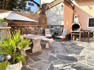 un patio al aire libre con mesa y chimenea en Residenza Tulipani, en Losone